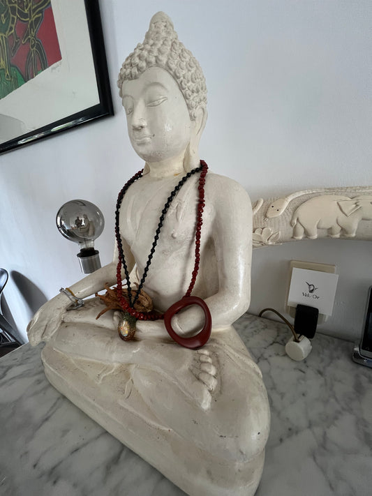 Sculptural luxury cock ring - the JNada by Velv'Or - displayed as wearable art on a Buddha statue, highlighting minimalist and avant-garde anatomical design.