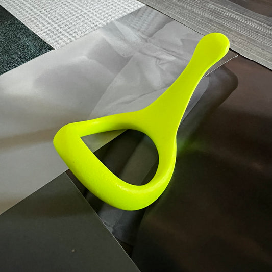 Velv'Or JNata Yellow Neon tumbled cock ring; a bright neon yellow, ergonomic 3D printed device designed for sexual wellness, placed on a textured surface.