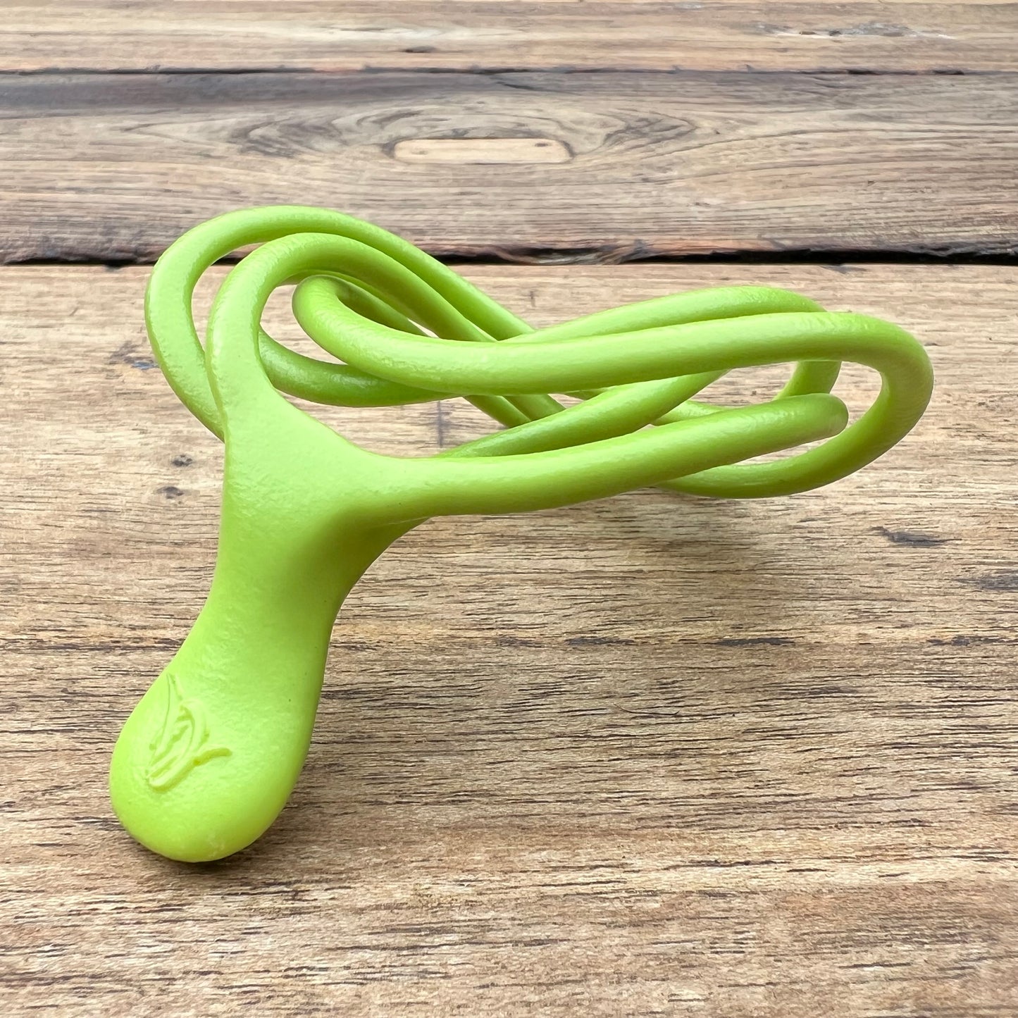 A polished green Velv'Or JNamo intimate massager featuring a unique, flexible looped ergonomic design with a smooth perineum part