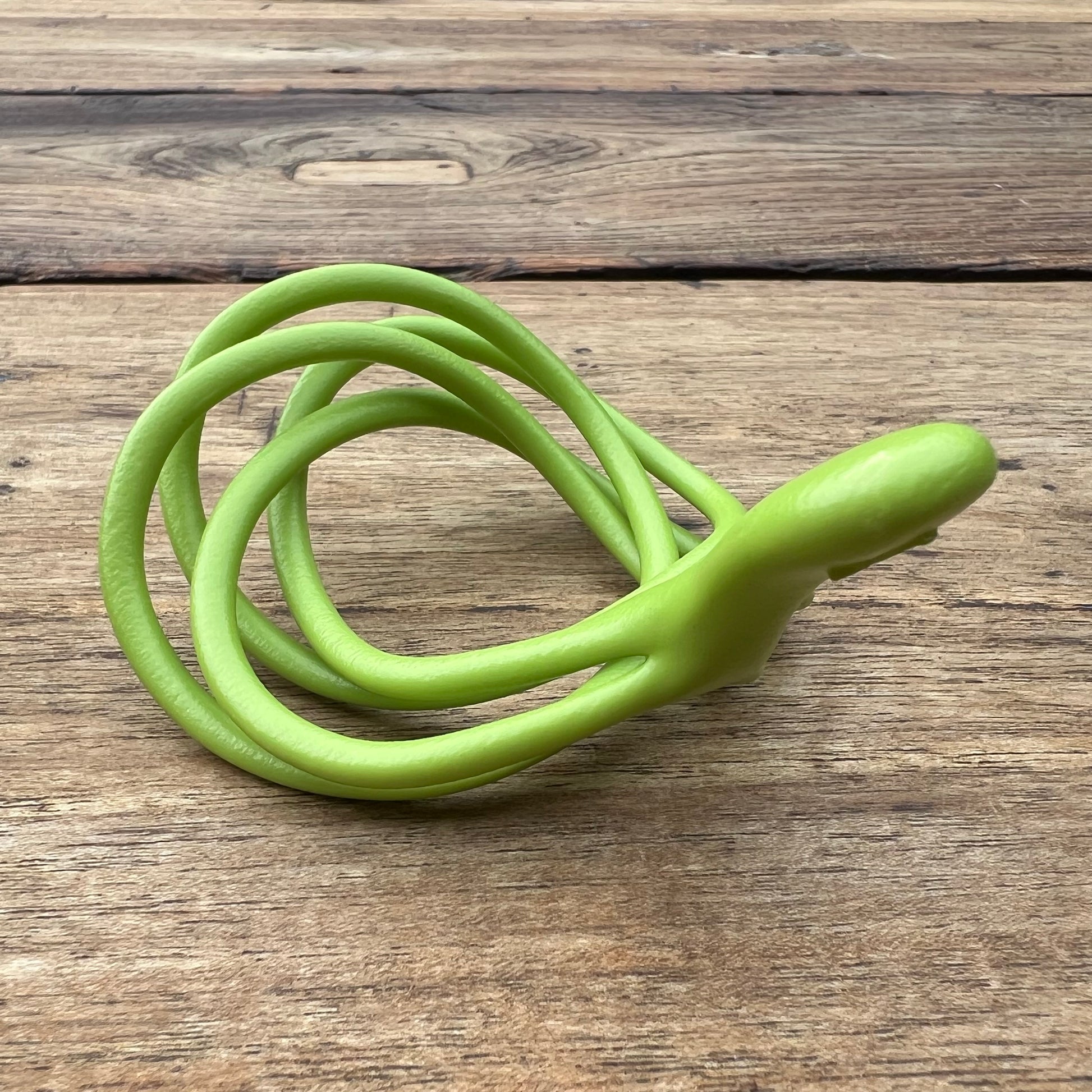 A polished green Velv'Or JNamo intimate massager featuring a unique, flexible looped ergonomic design with a smooth perineum part