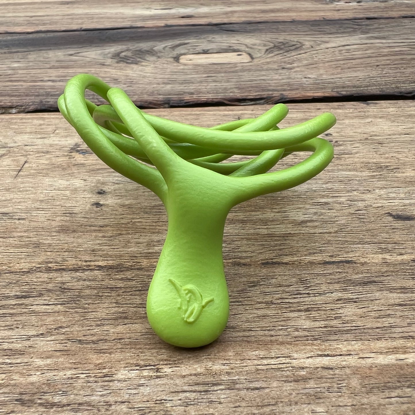 A polished green Velv'Or JNamo intimate massager featuring a unique, flexible looped ergonomic design with a smooth perineum part